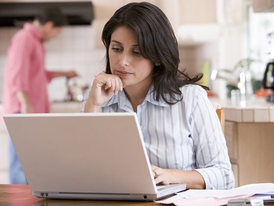 A woman reviewing documents on her computer.