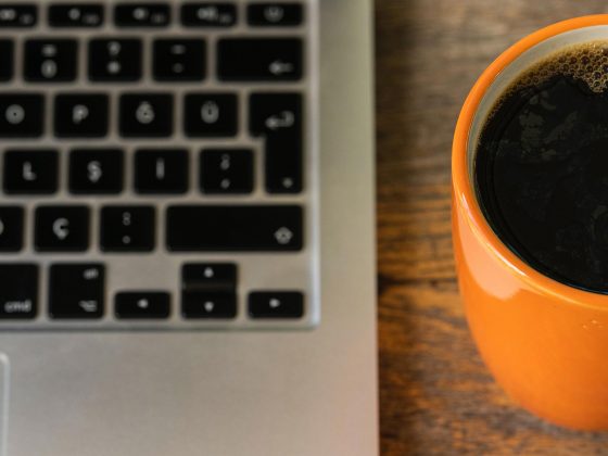 Is your technology cup half empty or half full? Computer sits beside full coffee cup.
