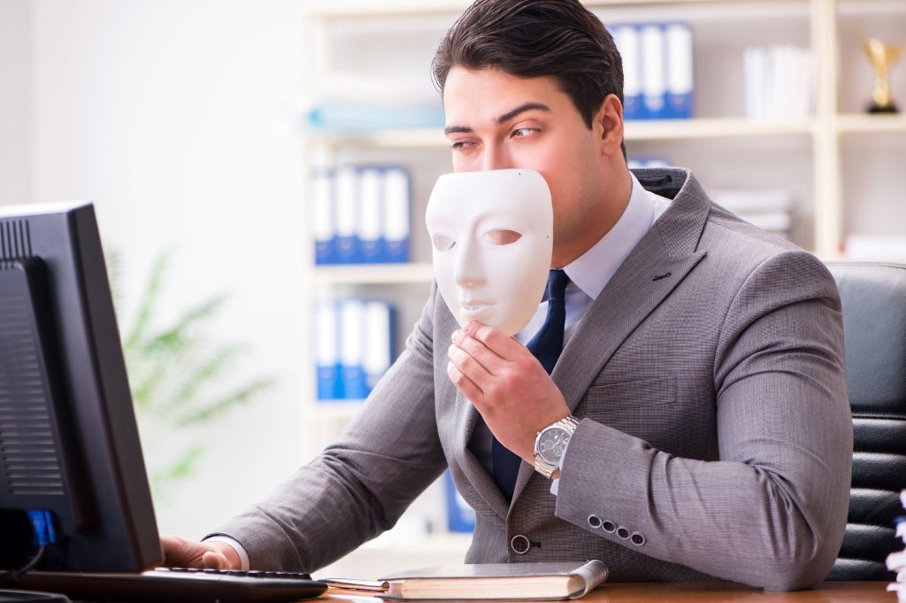 An imposter hides behind a mask and computer to trick people out of their tax refund.